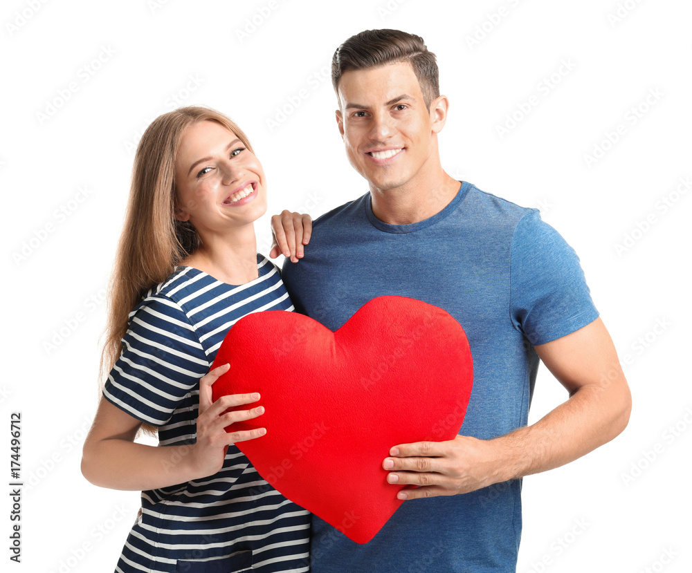 Young couple with pillow in heart shape, isolated on white