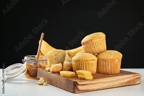 Composition with banana muffins and honey on table