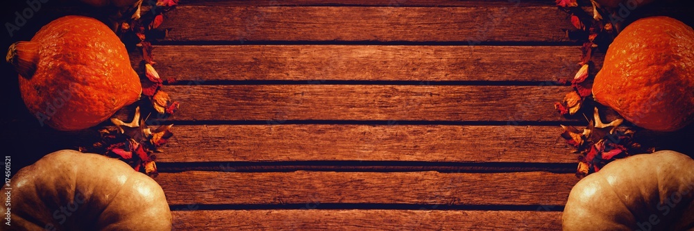 Naklejka premium Pumpkins with dried petals on table