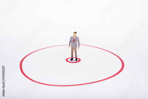 Miniature business man in red circle over white backdrop or background.