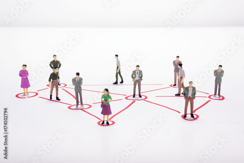 Miniature business people in conection scheme over white backdrop or background.