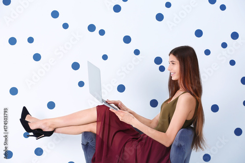 Young woman with laptop on ...