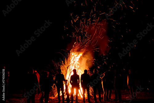 Tela People stand near a big fire at night