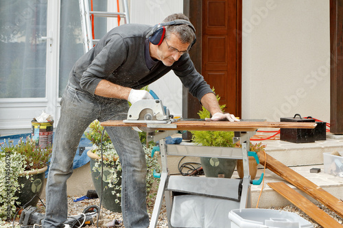 homme bricole avec une scie circulaire photo