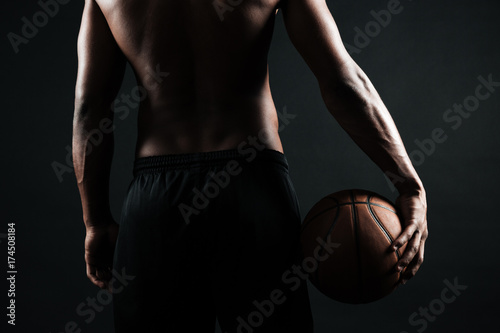 Cropped back view of afro american basketball player, holding ball