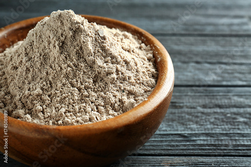 Superfood powder in bowl on wooden table