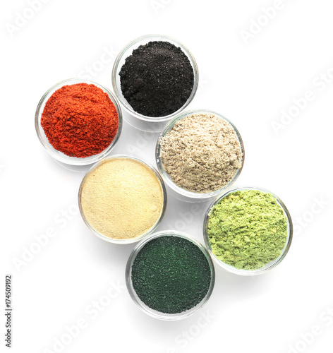 Different colorful superfood powders in bowls on white background
