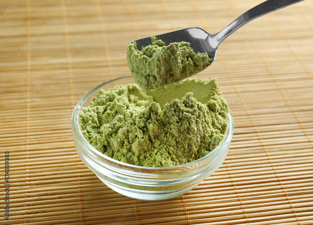 Superfood powder in bowl and spoon on table Superfood powder in bowl and spoon on table