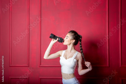 Girl in a yellow swimsuit in the gym teaches yoga with dumbbells