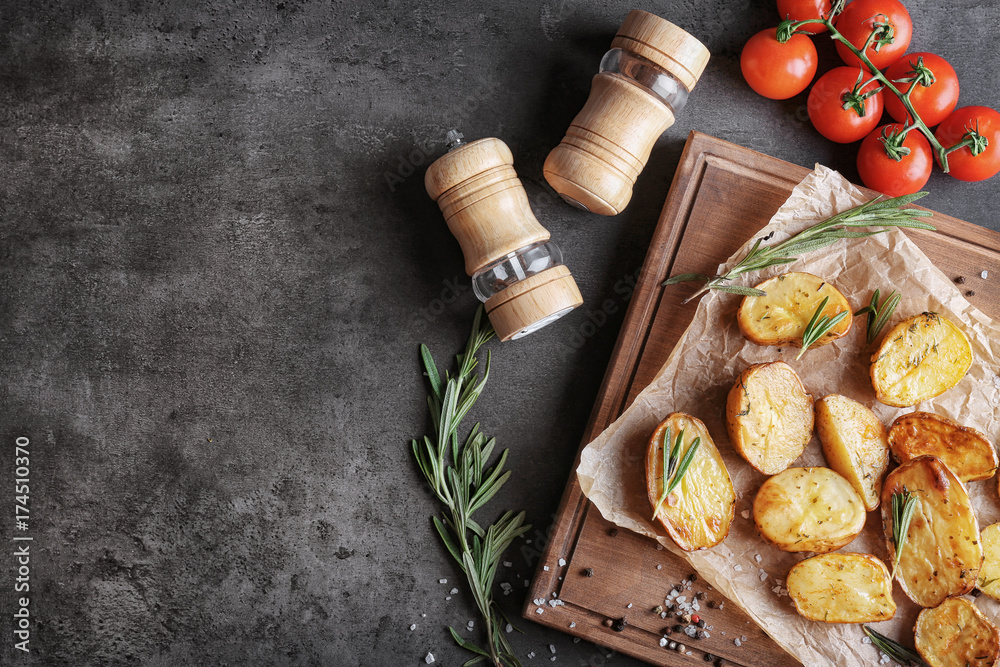 Board with delicious rosemary potatoes on table