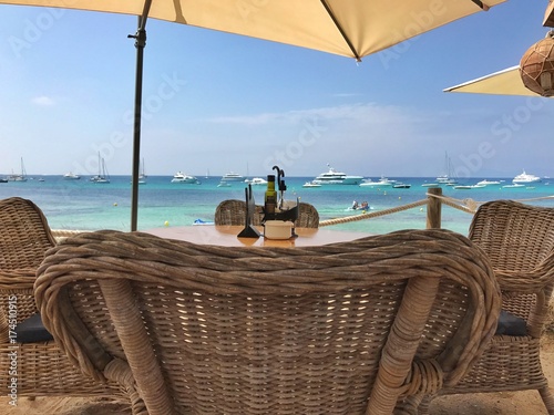 Essenstisch vor Meer in Türkis Farben auf Ibiza/Formentera in Spanien auf den Balearen mit Yachten vor dem Strand