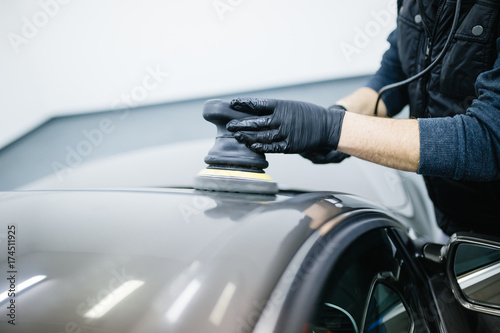 Car detailing - Hands with orbital polisher in auto repair shop. 