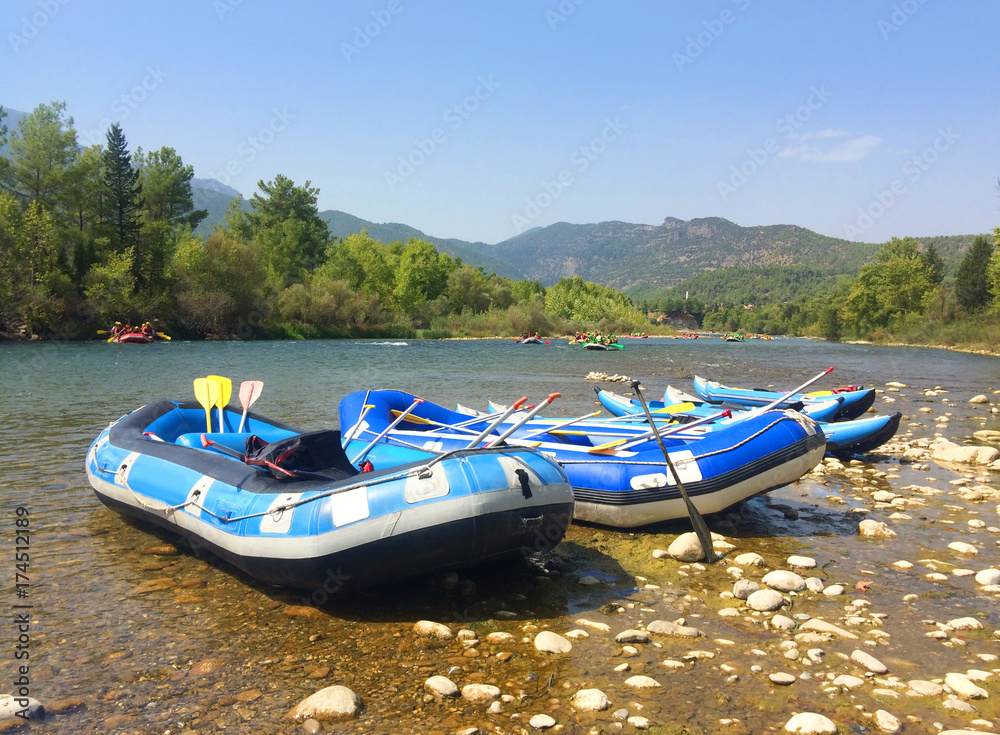 Fototapeta premium Inflatable boats (rafts) for rafting along a mountain river in front of a beautiful scenery