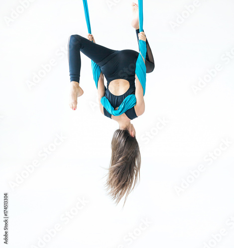 Fly yoga in a white gym. Gymnastics performs physical exercises for fly yoga