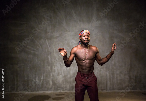 
African American dancing breakdance at a health sports center. Man teaches fitness exercises in the gym