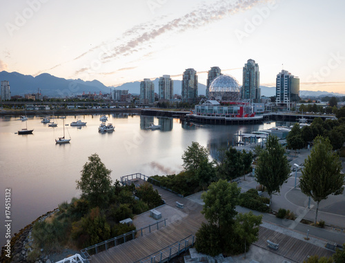 Aerial panoramic view of the modern city building skyline during a vibrant summer sunrise. Taken in False Creek, Downtown Vancouver, British Columbia, Canada.
