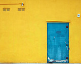 Aqua blue industrial door on a bright yellow building