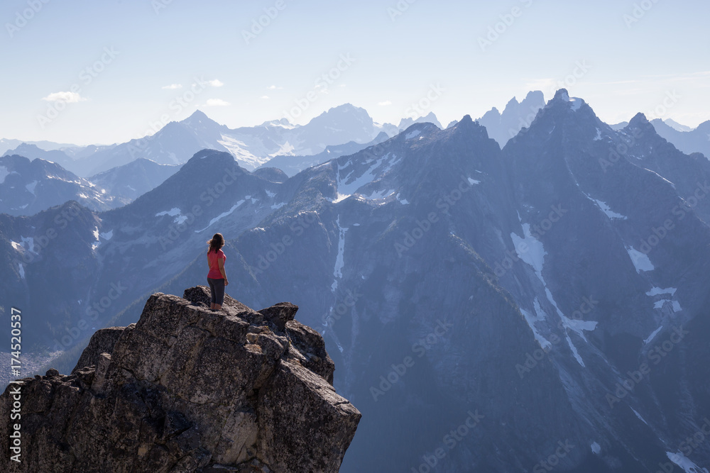Woman enjoying the beautiful Canadian Mountain Landscape view on top of the peak. Taken on top of MacDonald Peak near Chilliwack, East of Vancouver, BC, Canada.