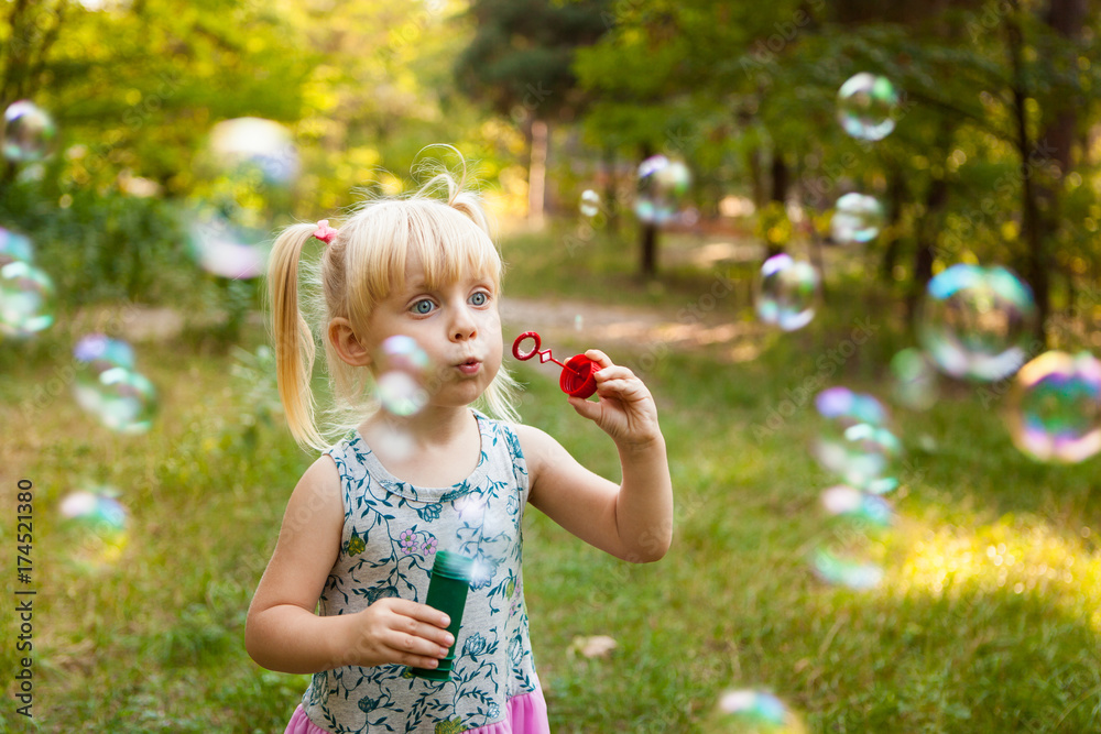 Child and soap bubbles in summer