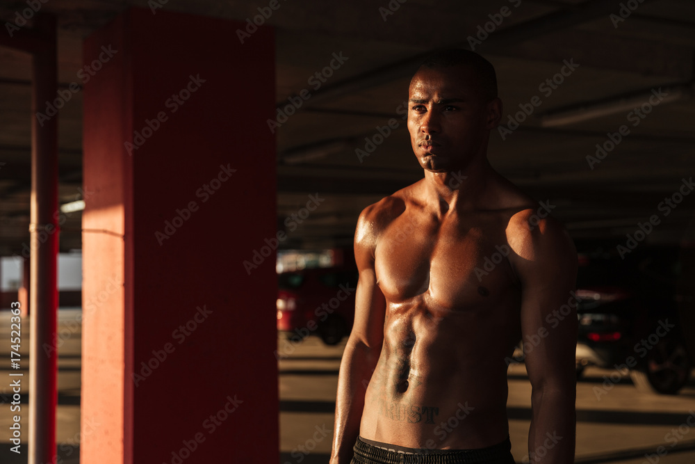 Fototapeta premium Portrait of a half naked muscular afro american sportsman