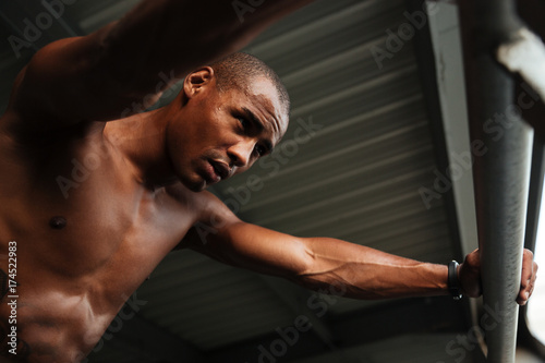 Fototapeta Naklejka Na Ścianę i Meble -  Bottom view of an exhausted sweaty half naked african sportsman