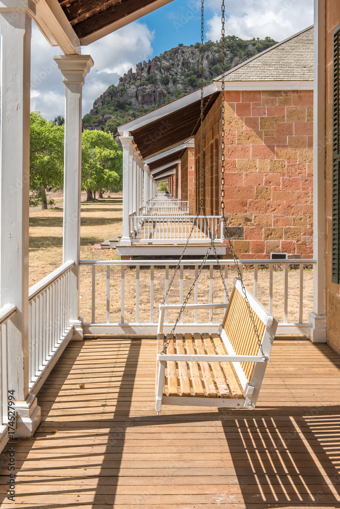 View along several porches with white swings - obrazy, fototapety, plakaty 