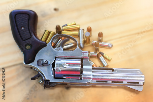 pistol with bullet on table wooden for outdoor sport and hunting photo