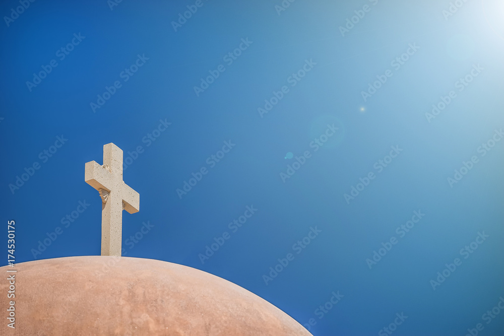White Christian cross in front of a cloudy sky with copyspace White Christian cross in front of a cloudy sky with copyspace