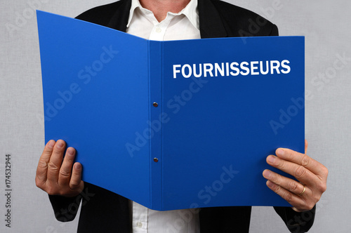 Homme consultant le dossiers des fournisseurs 