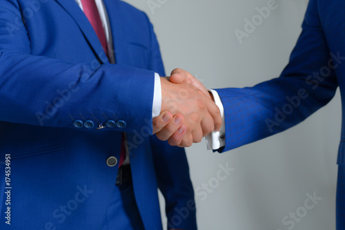 Businessmen hands in formal suits greet each other. Company leaders