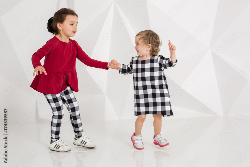 Children sisters play together on white background Children sisters play together on white background