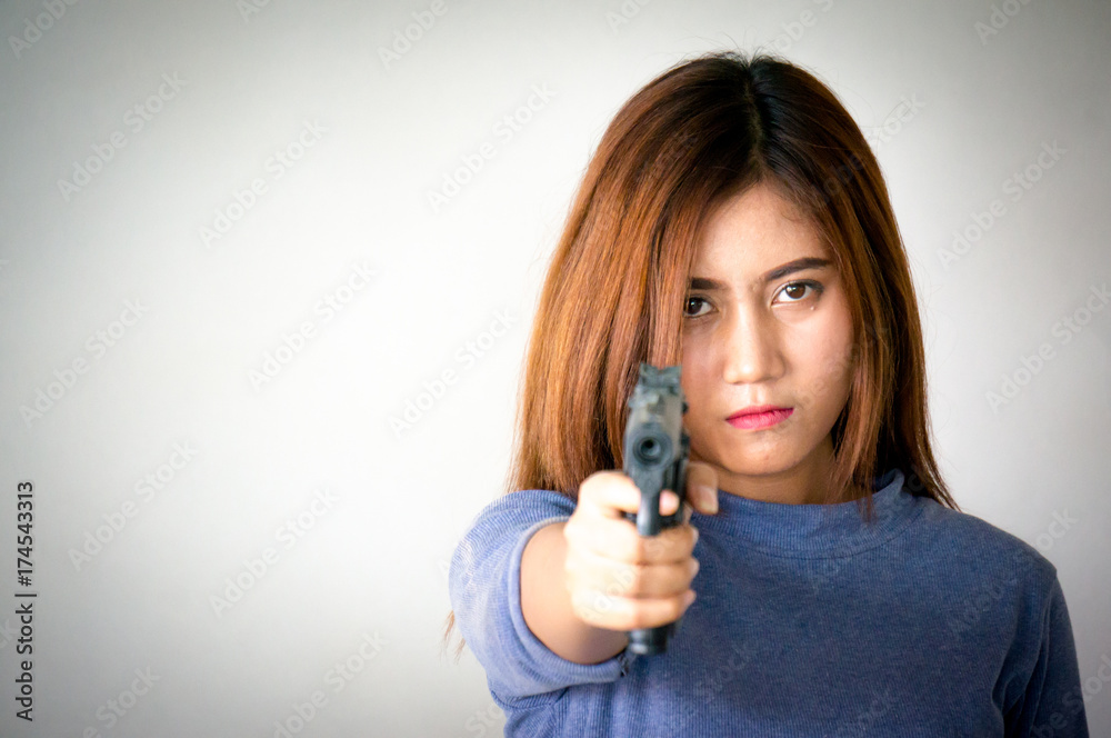 Woman holding gun in hand and aim at photographer Woman holding gun in hand and aim at photographer