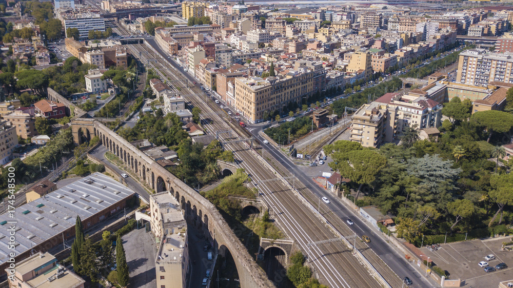 Fototapeta premium Vista aerea di un tratto di ferrovia italiana che attraversa la città di Roma est tra il quartiere Pigneto e la via Tuscolana. I binari dividono in due la capitale d' Italia.