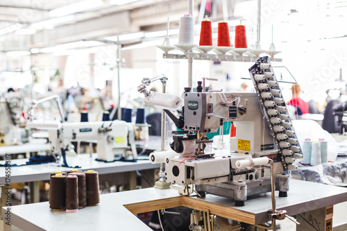 Professional sewing machine with different colors of threads in the textile factory.