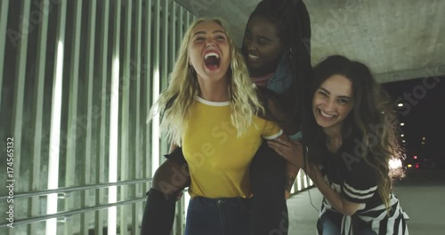 Young girlfriends having fun together in the city at night