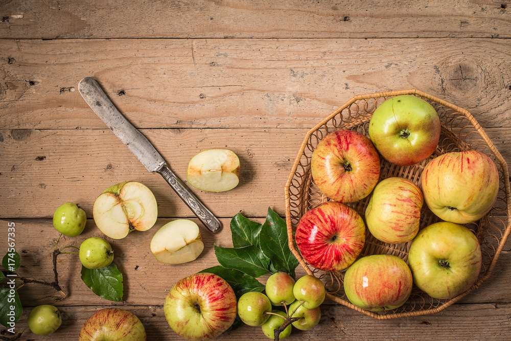 Composition with fresh apples on old wooden table.