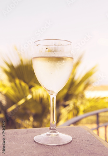 Glass of white wine over natural background