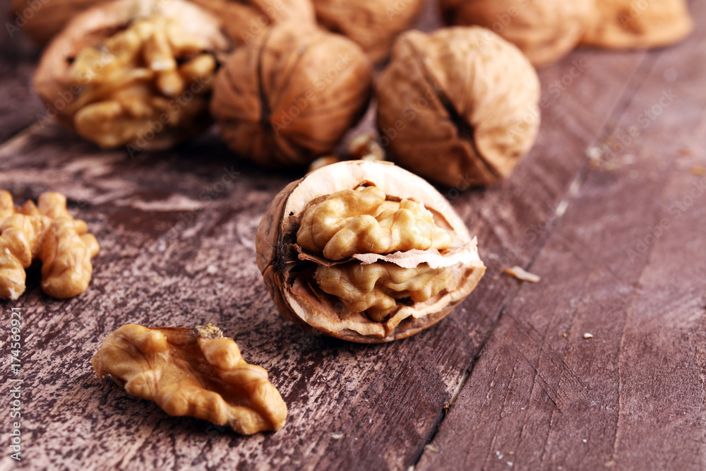 Walnut kernels and whole walnuts on rustic old wooden table. Walnut kernels and whole walnuts on rustic old wooden table.