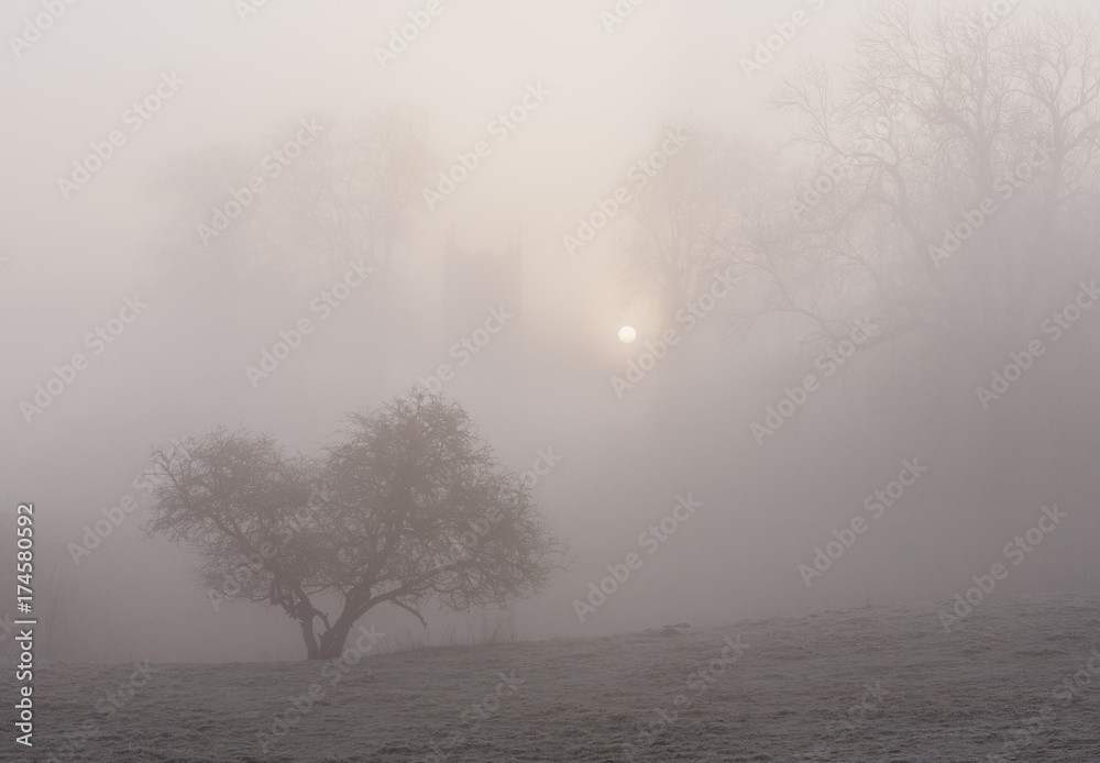 Sunrise through fog behind Hilborough Church. Norfolk, UK. Sunrise through fog behind Hilborough Church. Norfolk, UK.