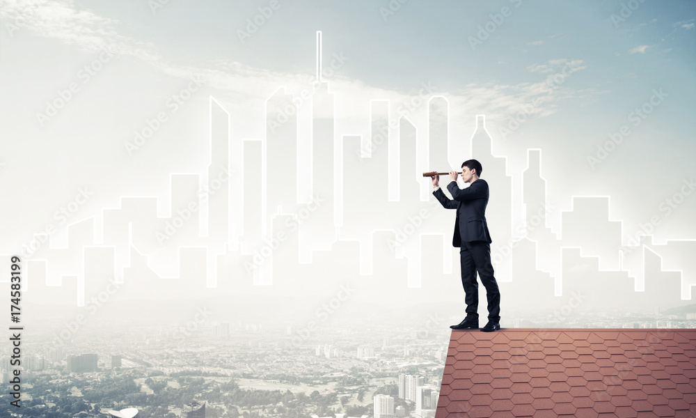 Engineer man standing on roof and looking in spyglass. Mixed med Engineer man standing on roof and looking in spyglass. Mixed med