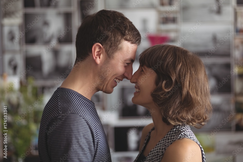 Smiling couple standing face to face in living room Smiling couple standing face to face in living room