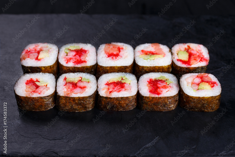Japanese food, sushi restaurant. Delicious futomaki sushi rolls with caviar, salmon and scallop served on black slate with free space for text design Japanese food, sushi restaurant. Delicious futomaki sushi rolls with caviar, salmon and scallop served on black slate with free space for text design