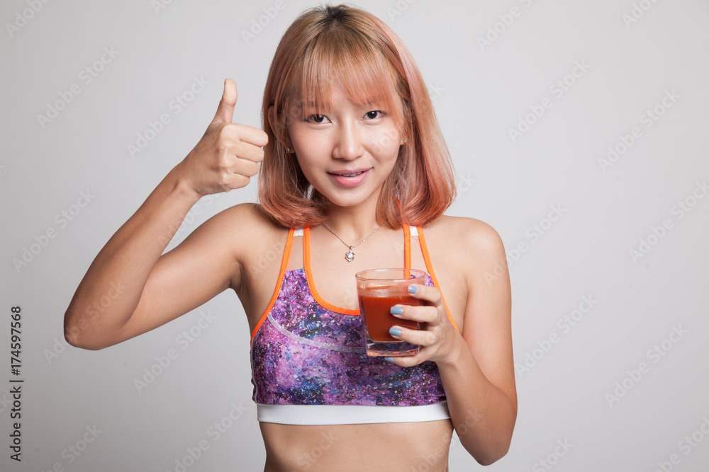 Beautiful healthy Asian girl thumbs up with tomato juice. Beautiful healthy Asian girl thumbs up with tomato juice.