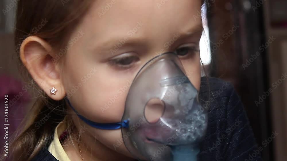 Sick girl with a sore throat makes inhalation with a mask on his face. Sick patient heals itself nebulizer. Sick girl with a sore throat makes inhalation with a mask on his face. Sick patient heals itself nebulizer.