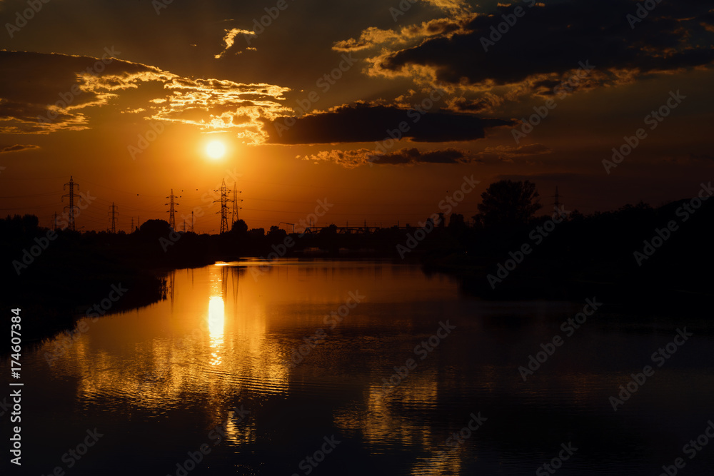 Orange Sunset By The River With Reflections And Silhouettes Of Industrial Area