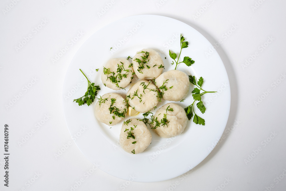 Khinkali on white plate with parsley and dill Khinkali on white plate with parsley and dill