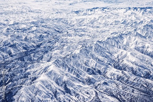 Alchemy of spring, mountains in spring: snow remains on Northern slopes and formed a beautiful forest of branching gorges - dendrogram. View from height, air photography.