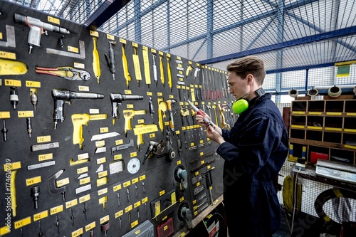 Male aircraft maintenance engineer examining various work tool
