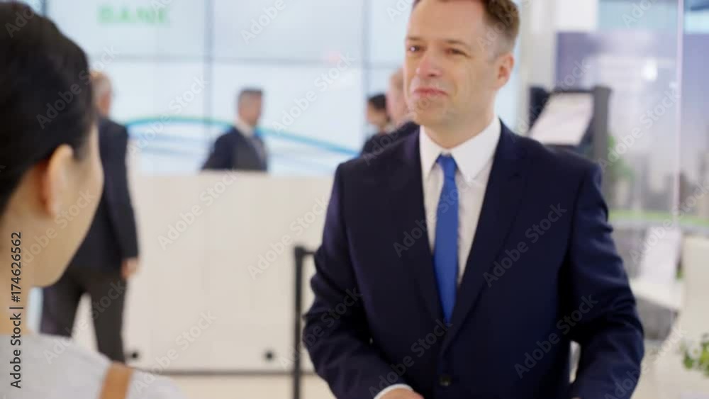  Customer with internet banking screen on phone talking to financial adviser