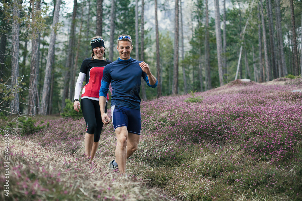 Two people running together in the forest Two people running together in the forest